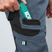 Load image into Gallery viewer, Detail view of Workwear Trousers featuring two cargo side pockets with flaps and two back pockets with Velcro fastening. 
